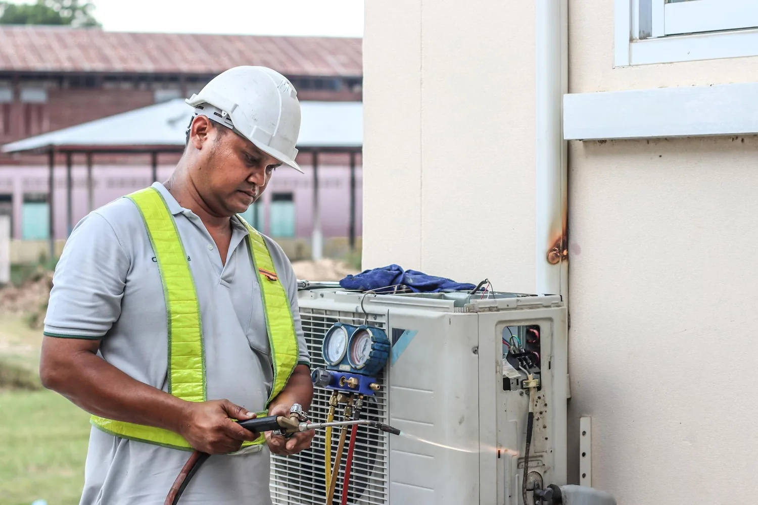 Technicien intervenant sur une unité extérieure de climatisation